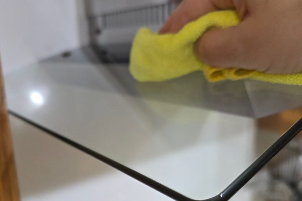 Hand wiping kitchen hood vent to remove light buildup